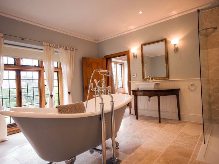 marble floor, cast iron roll top bath and basin on antique washstand