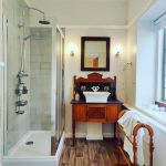 Bathroom with basin on antique washstand, shower to left