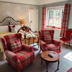 Luxury Bedroom with iron frame and two tartan arm chairs